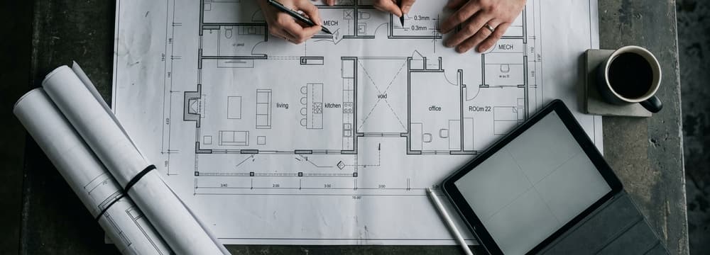 Two people marking up a printed floorplan together